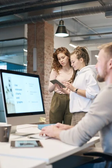why-choose-us Une équipe variée travaillant ensemble sur des stratégies de marketing digital à une table, avec des ordinateurs portables et des tablettes.